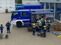 Junghelfer bauen aus Rundhölzern ein Hindernis